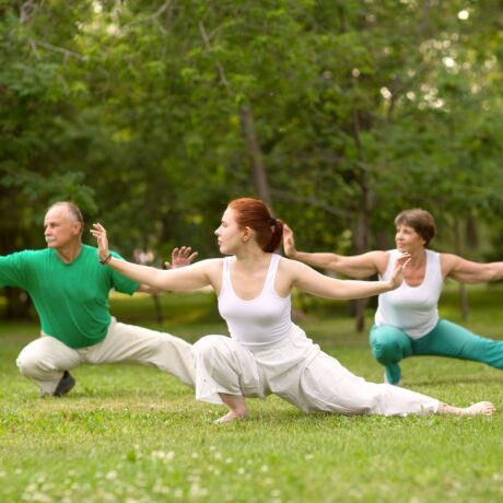 Grup de oameni care practică tahi chi într-un parc, un tip de exerciții pentru artrita reumatoidă