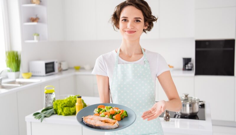 Femeie care servește somonul, unul dintre cele mai bune alimente pentru hipertensiune