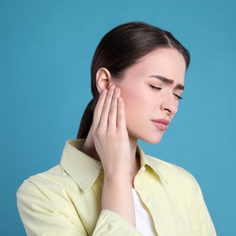 O femeie care se confruntă cu o durere de ureche