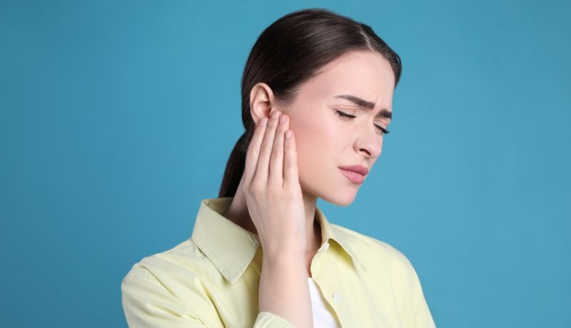 O femeie care se confruntă cu o durere de ureche