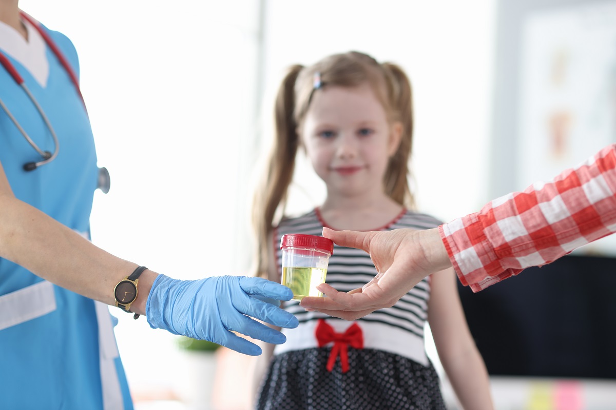 Probă de urină la medic și o fetiță fotografiată în fundal