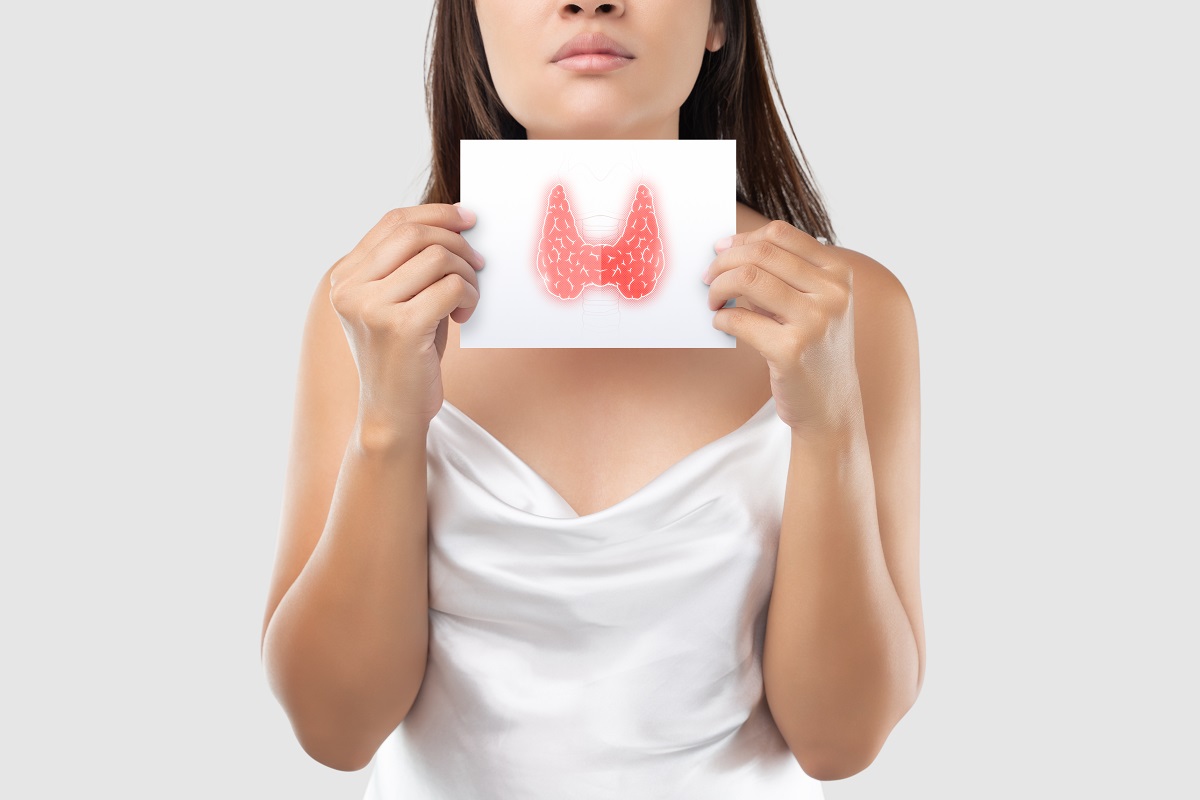 Femeie care arată un desen cu glanda tiroidă