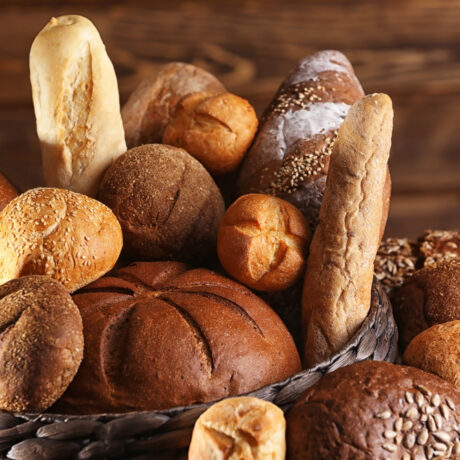 Mai multe tipuri de pâine, într-un coș, pe o masă