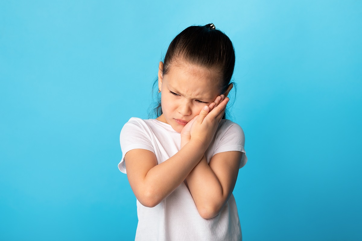 Fetiță cu durere de obraz, unul dintre simptomele pe care le are oreionul