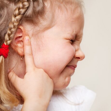 Fetiță cu durere de ureche care semnalează otita