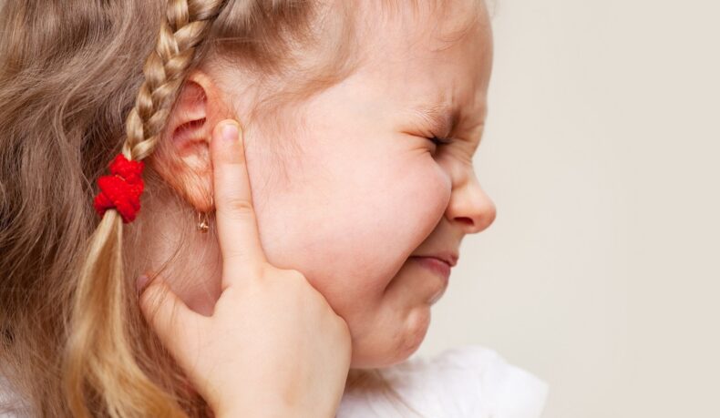 Fetiță cu durere de ureche care semnalează otita
