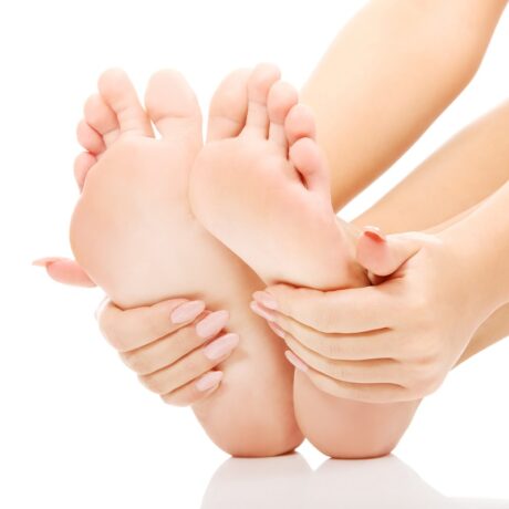 Femeie care își analizează picioarele. Semnele unui colesterol crescut sunt vizibile în sănătatea picioarelor.