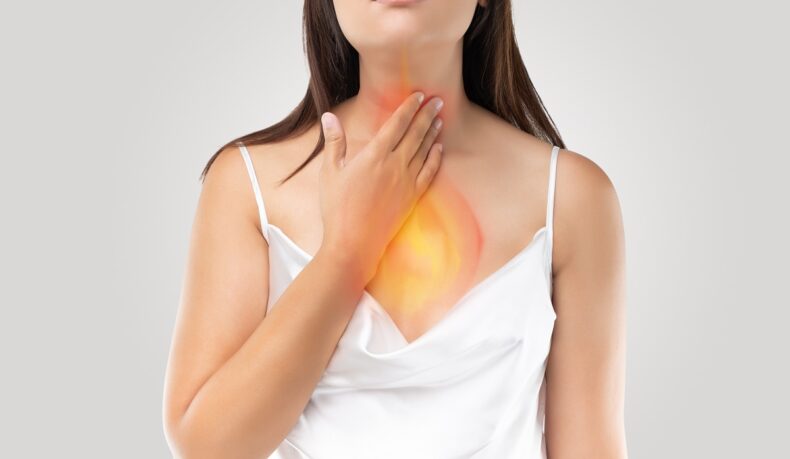 femeie cu arsură în piept cauzată de refluxul gastroesofagian