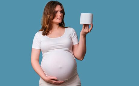Gravidă care ține în mână o hârtie igienică, sugestiv pentru constipația în sarcină