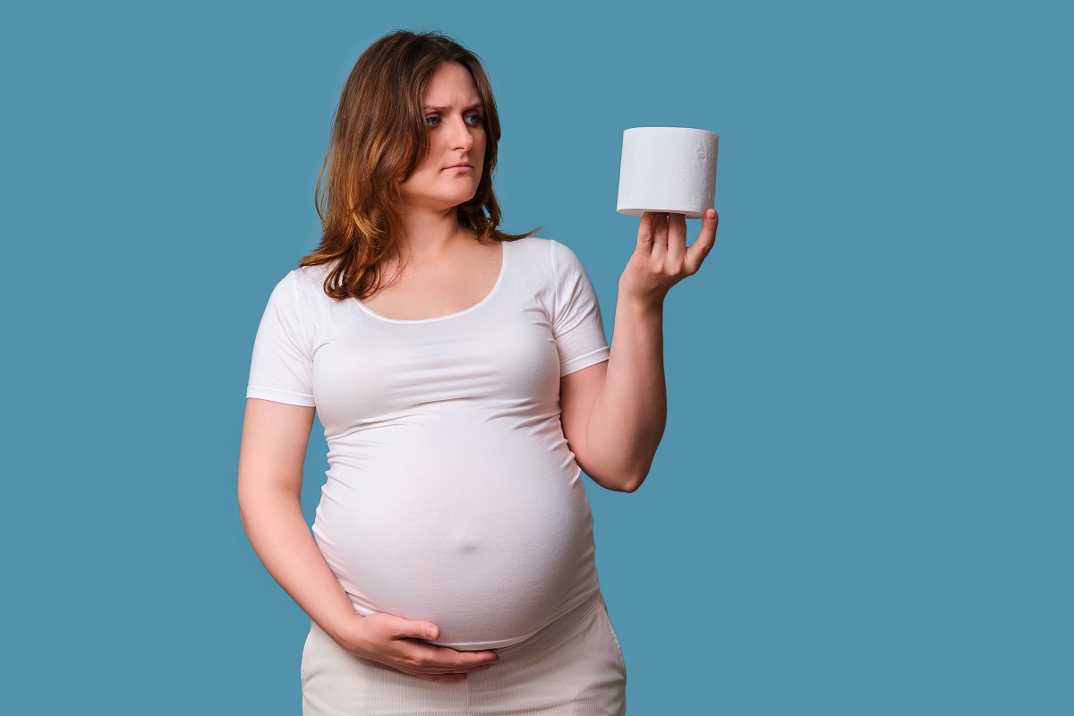 Gravidă care ține în mână o hârtie igienică, sugestiv pentru constipația în sarcină