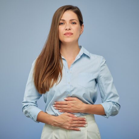 Femeie cu durere de stomac, unul dintre simptomele Helicobacter pylori.