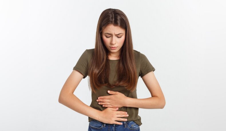 Femeie cu durere abdominală, unul dintre simptomele de avort spontan