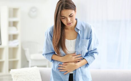 Femeie cu durere de burtă. Durerile abdominale sunt printre primele simptome de cancer colorectal