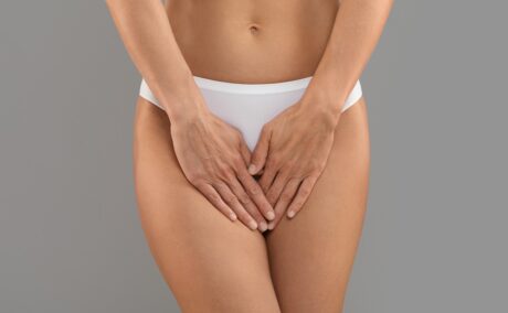 Femeie care își acoperă zona intimă cu palmele, sugestiv pentru infecții precum candidoza vaginală