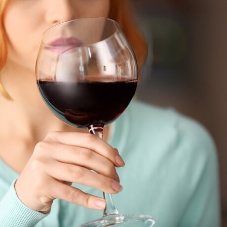 femeie care bea un pahar de vin roșu