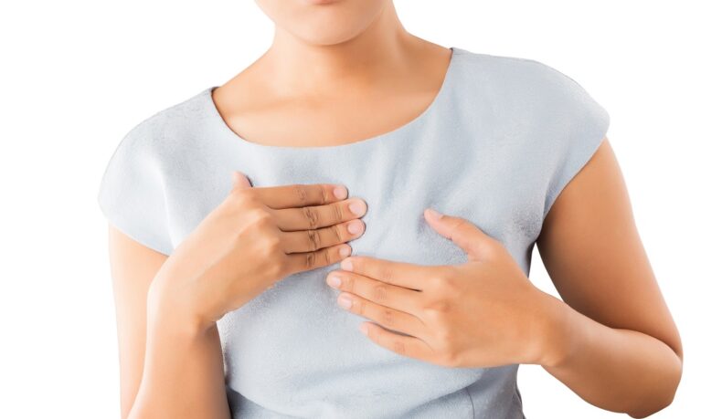 Femeie cu mâna la piept care suferă de arsuri gastrice, simptom care poate semnala un infarct „dus pe picioare”
