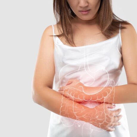 Femeie cu dureri abdominale și sistem digestiv desenat, sugestiv pentru boala Crohn