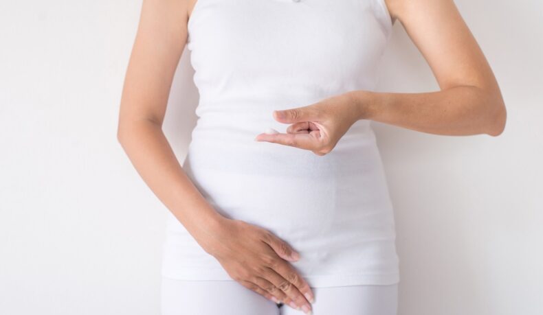 Gravidă cu cremă pe degete, sugestiv pentru cremele vaginale recomandate pentru candidoza în sarcină
