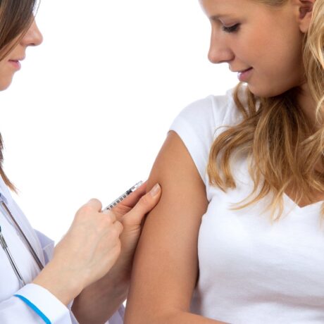 Medic care vaccinează o femeie în braț, sugestiv pentru vaccinul antigripal în sezonul 2023-2024