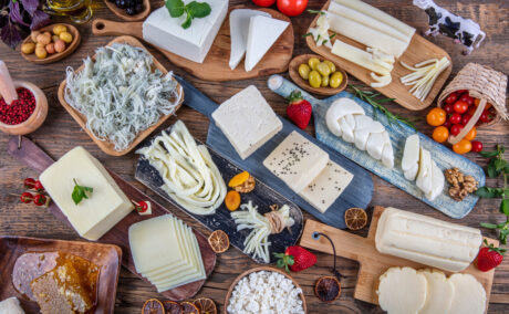 Mai multe sortimente de brânză pe o masă din lemn