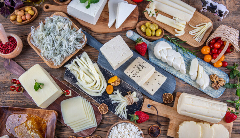 Mai multe sortimente de brânză pe o masă din lemn