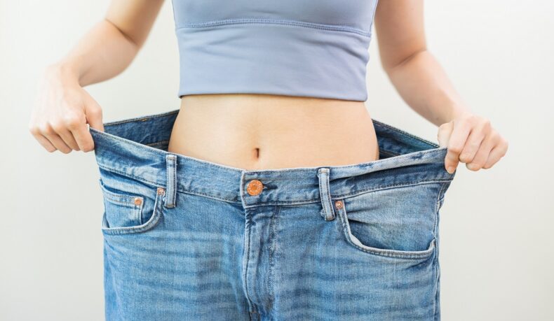 Femeie slabă cu pantaloni foarte largi, sugestiv pentru operația de micșorare a stomacului