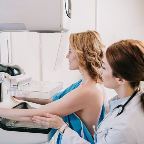 Medic cu pacientă care face o mamografie
