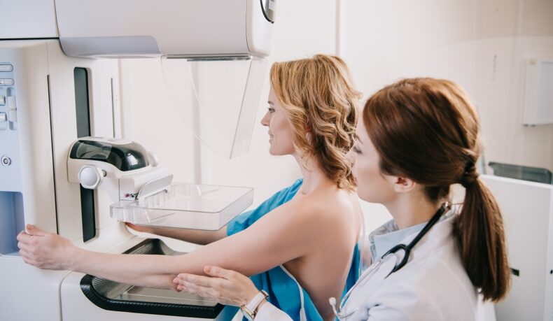Medic cu pacientă care face o mamografie