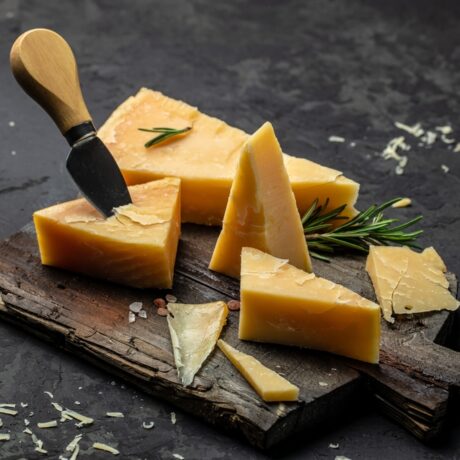 Bucăți de brânză cheddar pe un tocător din lemn