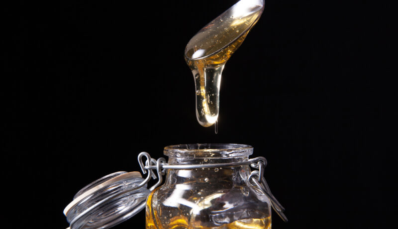Un borcan din sticlă cu nectar de agave și o lingură