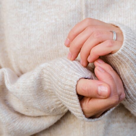 O femeie își apropie mâinile pentru a le încălzi