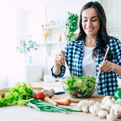 Femeie în bucătărie care amestecă o salată
