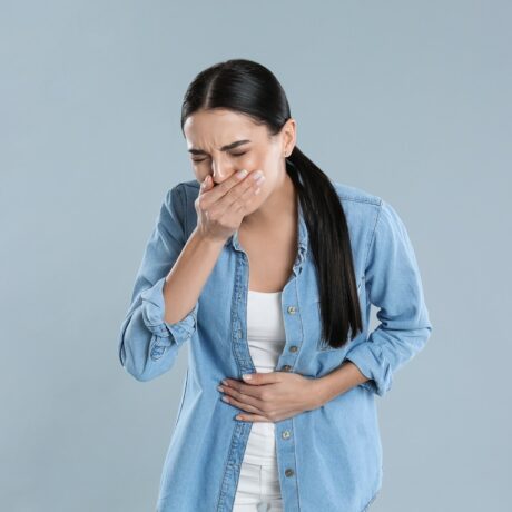 Femeie cu durere de burtă și stare de greață, sugestiv pentru indigestie alimentară