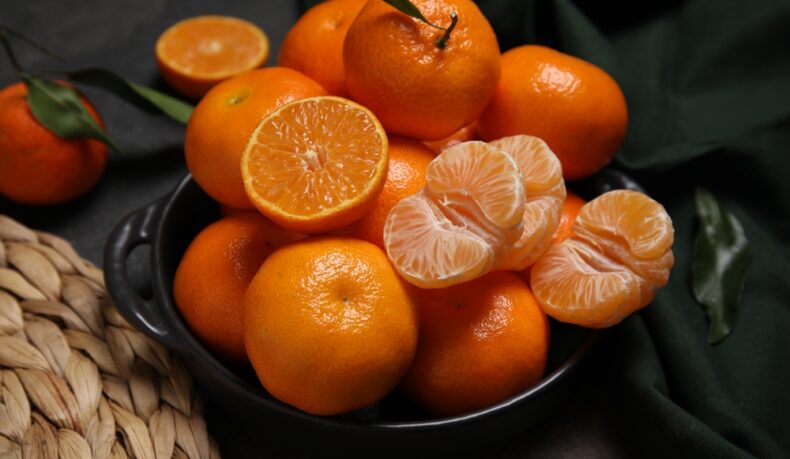 Un castron cu portocale și felii de portocale