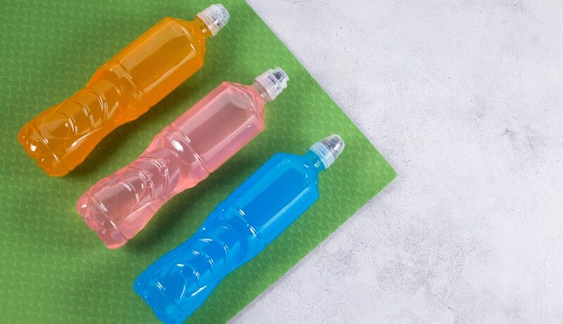 Trei sticle în culori diferite: portocaliu, roz și albastru