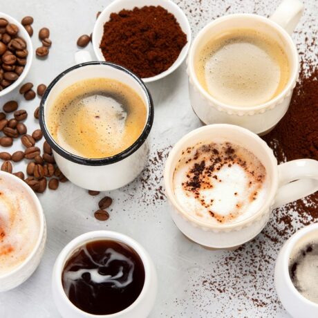 Cești de cafea și boabe de cafea, sugestiv pentru legătura dintre performanțele cognitive și cofeina în exces