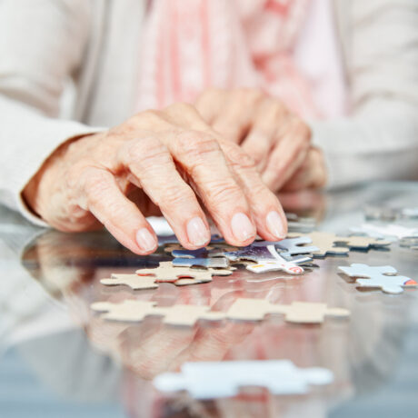 O femeie în vârstă rezolvă un puzzle