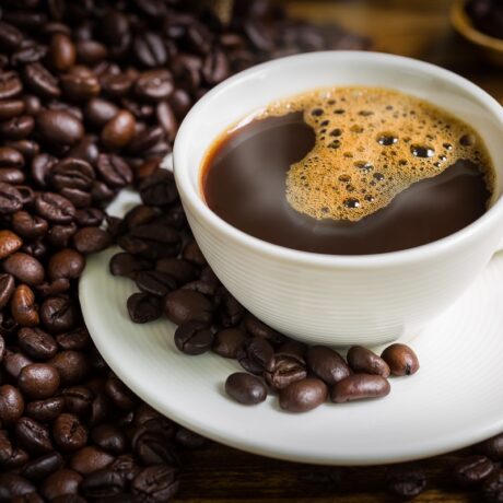 Ceașcă de cafea cu boabe de cafea în jur