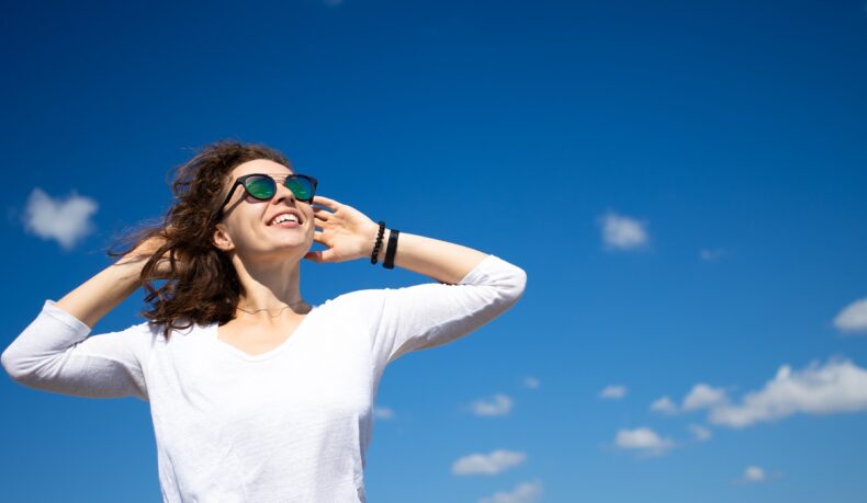 Femeie care se uită la soare cu ochelari de soare