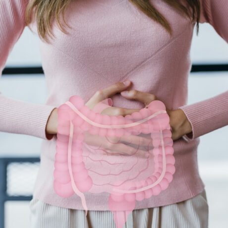 Femeie cu durere de burtă și ilustrație cu intestine, sugestiv pentru inflamația intestinală