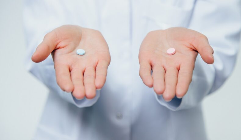 Pastile colorate ținute în palme, sugestiv pentru ibuprofen și alte medicamente