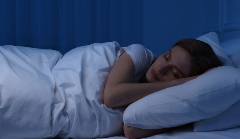 O femeie tânără care doarme în pat