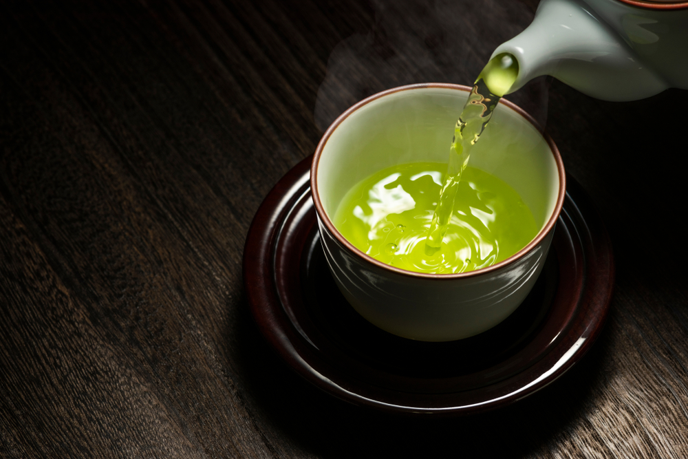 O ceașcă cu ceai verde și un ceainic