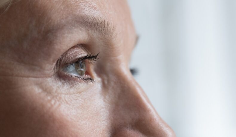 Detaliu cu ochi de femeie în vârstă care se uită în față, sugestiv pentru probleme de vedere - semnul care prezice demența