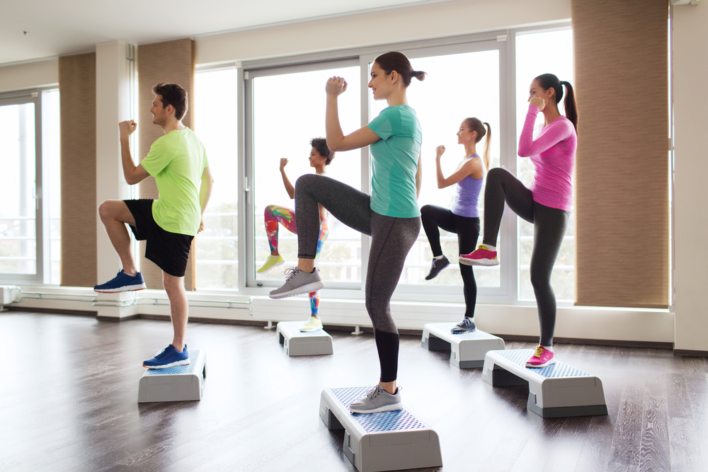 Grup de femei care execută exerciții aerobice într-o sală de fitness