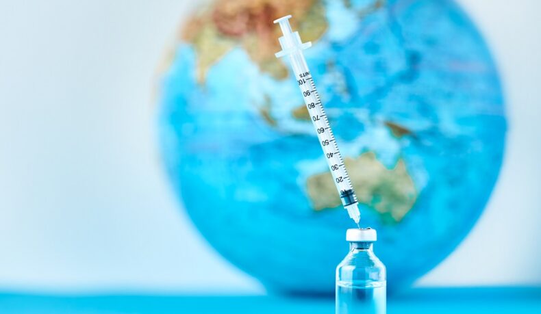 Vaccin și seringă în prim-plan, globul pământesc în fundal, detaliu sugestiv pentru vaccinuri pentru țări tropicale