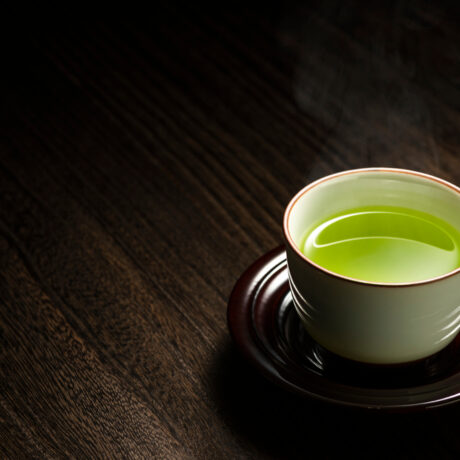 O ceașcă cu ceai verde pe o farfurie