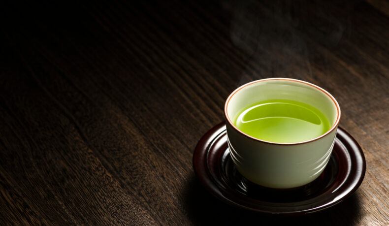 O ceașcă cu ceai verde pe o farfurie
