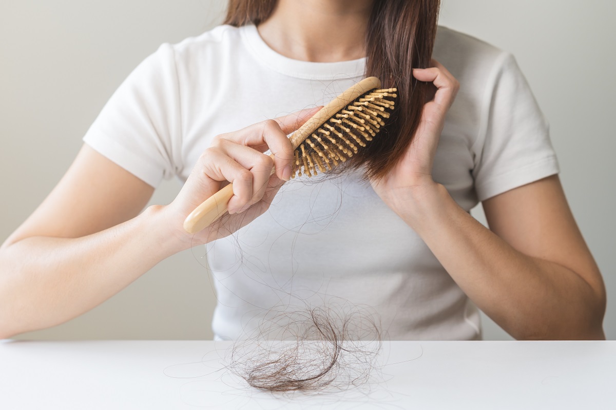 Detaliu cu femeie care își periază părul și multe fire de păr căzute