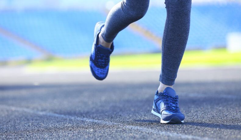 O femeie tânără care aleargă pe un stadion